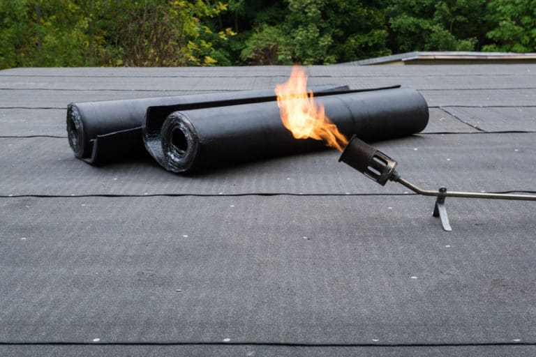 Flat Roof Materials - Torch On Roofing Materials next to a Lit Torch
