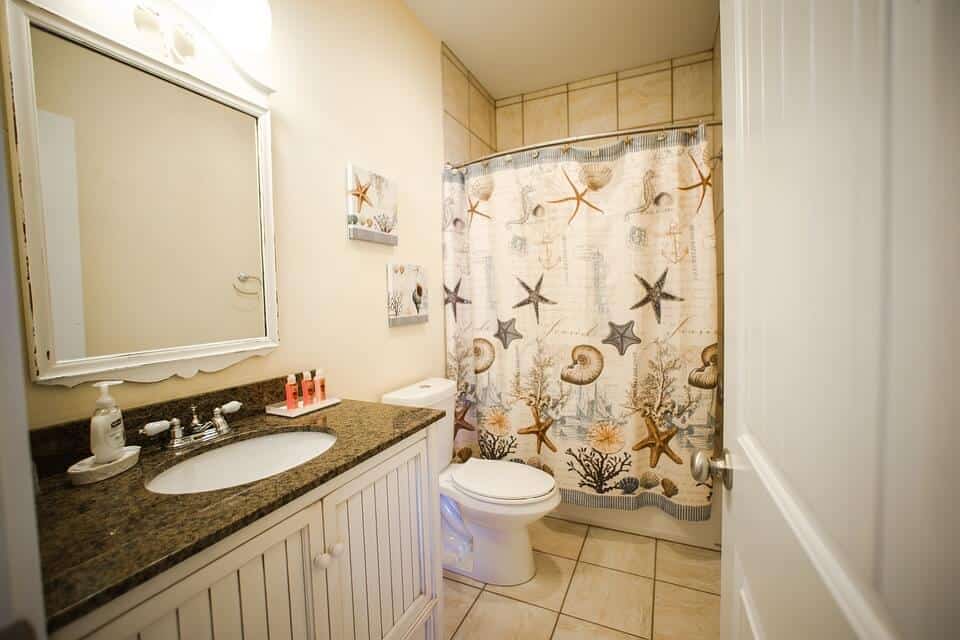 How to Start Remodeling a Bathroom - A Newly Remodeled Bathroom with Flowered Shower Curtain and New Flooring