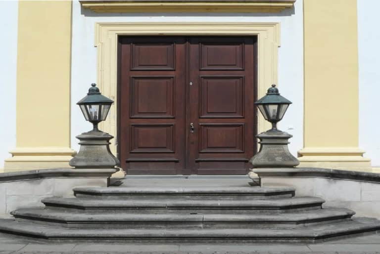 Worst Home Improvements for ROI - A Yellow Home with a Brown Fiberglass Grand Entry and Steps