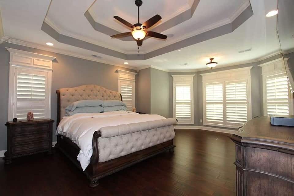 Worst Home Improvements for ROI - A Beautiful Master Bedroom Suite with Lots of Space, Wood Floors, and a Brown Wood Bed with Peach Colored Covers