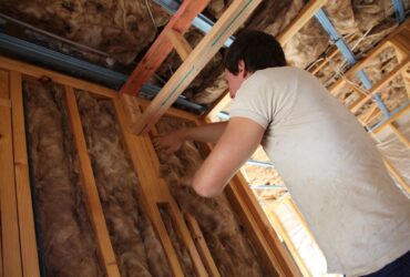 A person installing insulation.