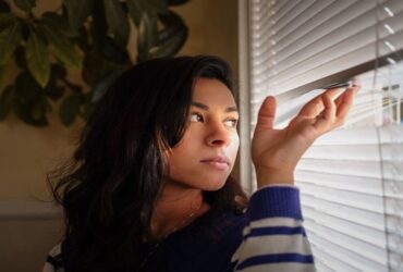 a woman is looking from a window