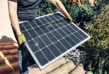 A person carrying a solar panel